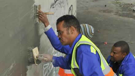 EPWP workers scrub away the spray